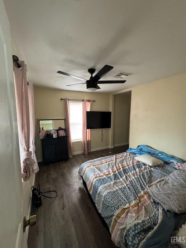 bedroom with a ceiling fan, visible vents, wood finished floors, and baseboards