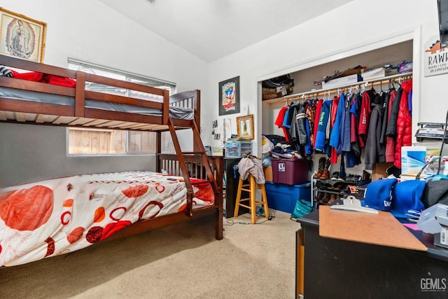 carpeted bedroom featuring lofted ceiling and a closet