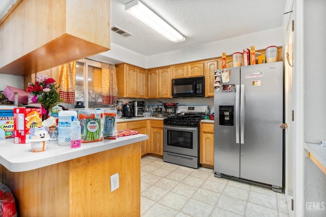 kitchen with light countertops, a peninsula, visible vents, and stainless steel appliances