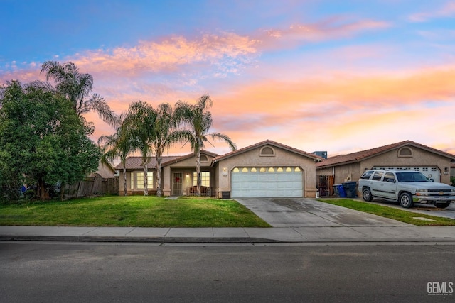 single story home featuring fence, stucco siding, concrete driveway, a front lawn, and a garage