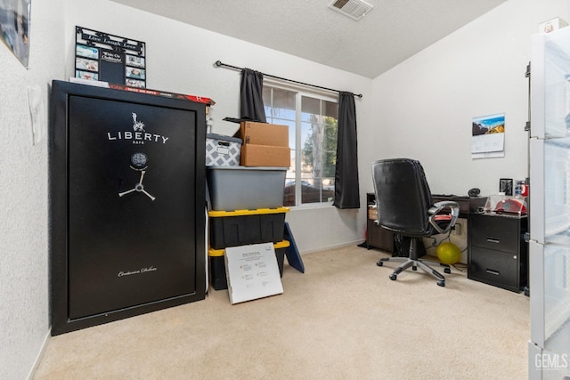 office featuring vaulted ceiling, visible vents, carpet floors, and a textured ceiling