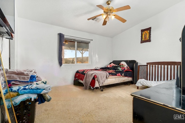 carpeted bedroom featuring visible vents, ceiling fan, and vaulted ceiling