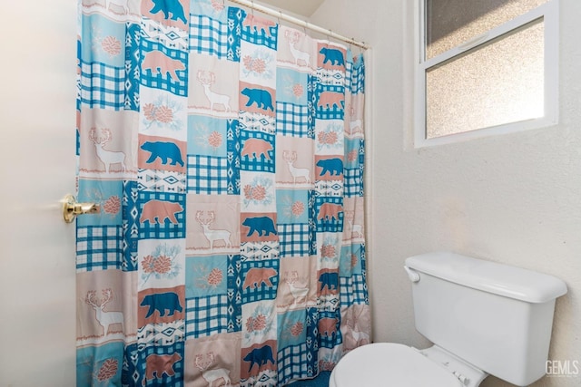 full bath featuring toilet and a shower with shower curtain