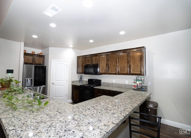 kitchen featuring black appliances, kitchen peninsula, and sink