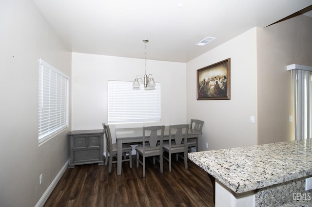 dining area featuring dark hardwood / wood-style flooring and a notable chandelier