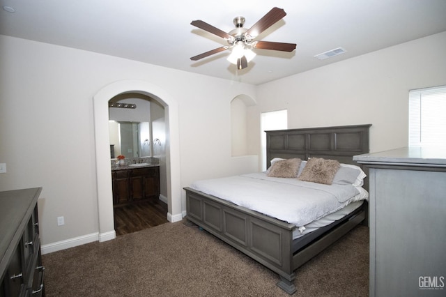 carpeted bedroom featuring ensuite bathroom and ceiling fan