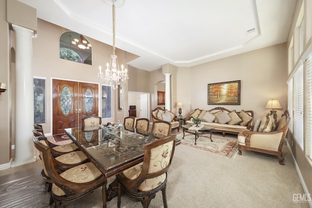 12504 Crown Crest Dr, Bakersfield, CA 93311 - dining area with decorative columns, a raised ceiling, a chandelier, and carpet flooring