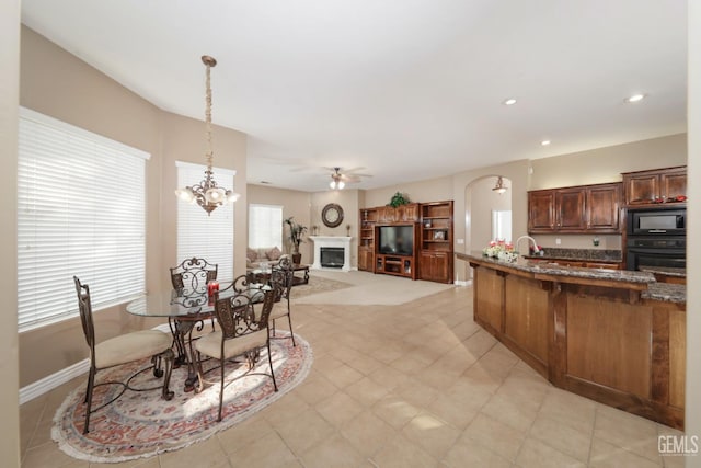 12504 Crown Crest Dr, Bakersfield, CA 93311 - dining space featuring arched walkways, a ceiling fan, recessed lighting, a fireplace, and a chandelier