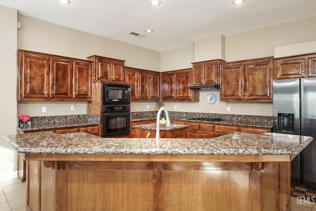 12504 Crown Crest Dr, Bakersfield, CA 93311 - kitchen with black appliances, a center island with sink, dark stone countertops, recessed lighting, and light tile patterned flooring