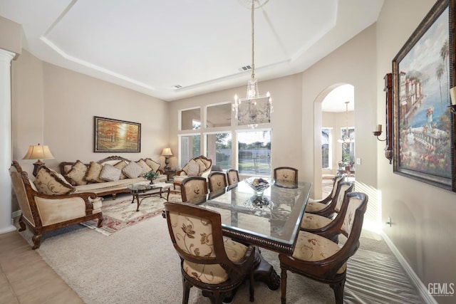 12504 Crown Crest Dr, Bakersfield, CA 93311 - dining space featuring a chandelier, arched walkways, tile patterned floors, and a tray ceiling