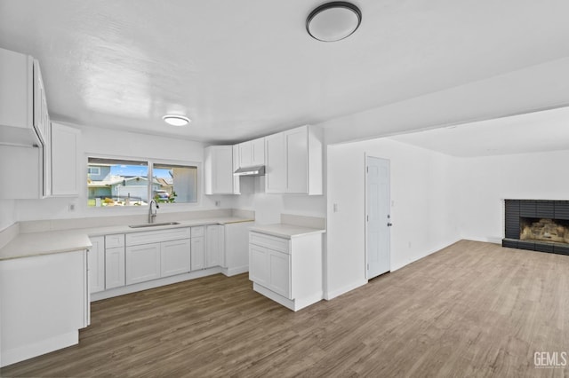 kitchen with dark hardwood / wood-style flooring, sink, and white cabinets