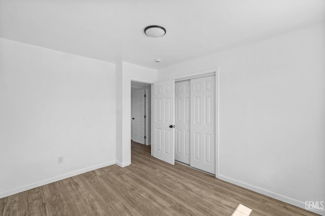 unfurnished bedroom with light hardwood / wood-style floors and a closet