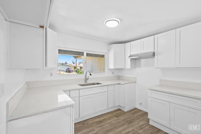 kitchen featuring sink, white cabinets, extractor fan, and light hardwood / wood-style flooring