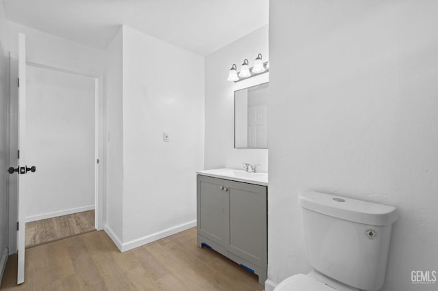 bathroom featuring hardwood / wood-style floors, vanity, and toilet