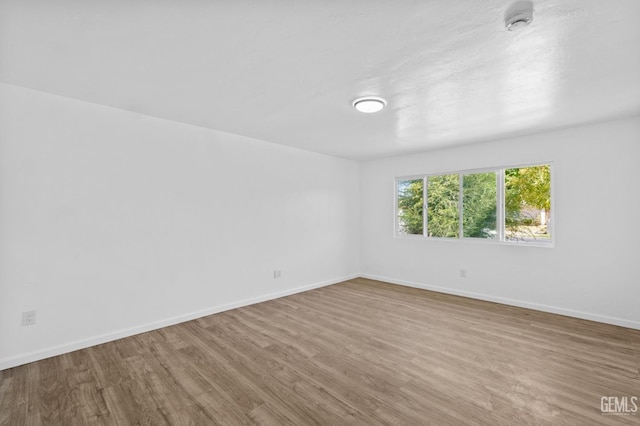 unfurnished room with hardwood / wood-style flooring