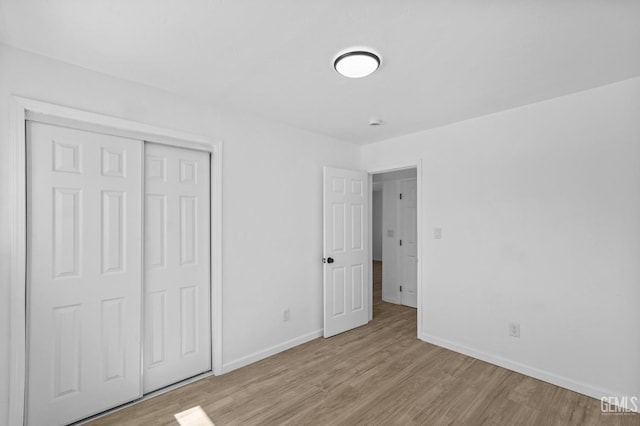 unfurnished bedroom featuring a closet and light wood-type flooring