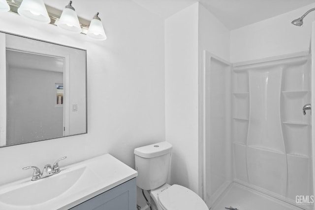 bathroom featuring vanity, toilet, and walk in shower