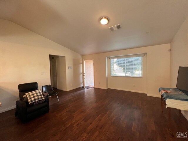 unfurnished room featuring dark hardwood / wood-style floors and lofted ceiling