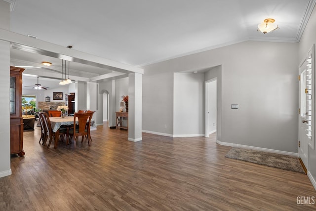 5512 Sicily Ct, Bakersfield, CA 93308 - dining space featuring a ceiling fan, dark wood-style flooring, crown molding, baseboards, and arched walkways