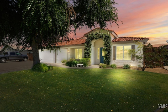 5512 Sicily Ct, Bakersfield, CA 93308 - mediterranean / spanish-style home featuring an attached garage, a tile roof, a yard, and stucco siding