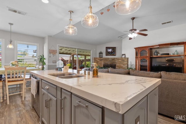 5512 Sicily Ct, Bakersfield, CA 93308 - kitchen featuring lofted ceiling, a sink, light wood-style floors, a ceiling fan, and a fireplace