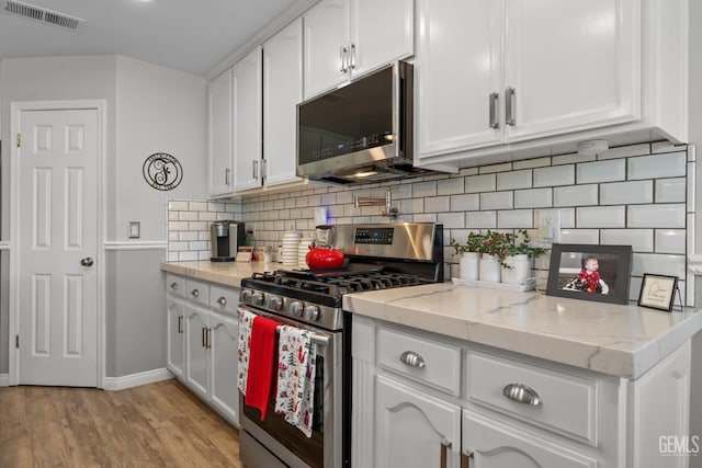 5512 Sicily Ct, Bakersfield, CA 93308 - kitchen featuring stainless steel appliances, white cabinets, tasteful backsplash, and light wood-style floors