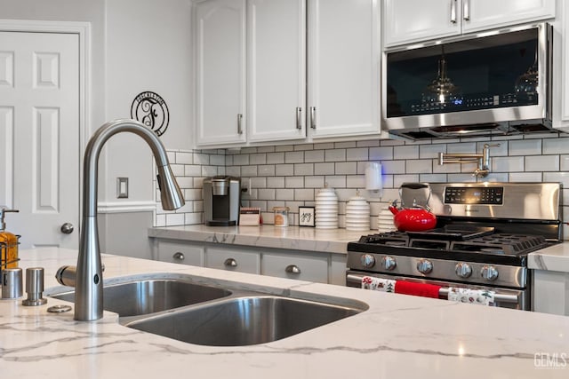 5512 Sicily Ct, Bakersfield, CA 93308 - kitchen with stainless steel appliances, a sink, white cabinetry, tasteful backsplash, and light stone countertops