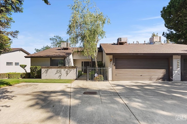 5600 Kirkside Dr Unit F, Bakersfield, CA 93311 - view of front of property with stucco siding, an attached garage, concrete driveway, and central AC