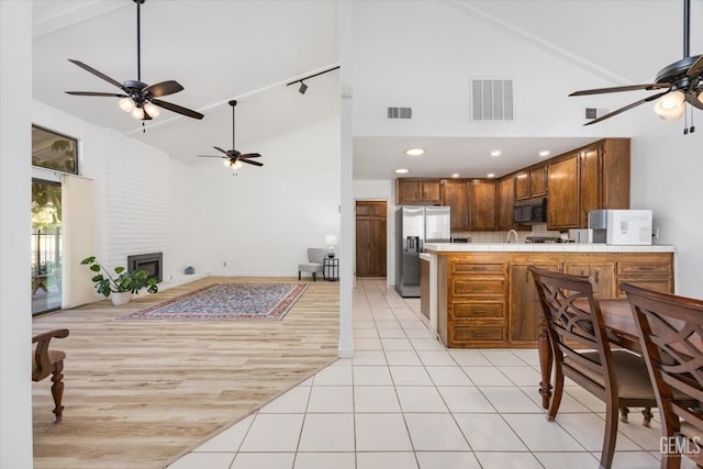 5600 Kirkside Dr Unit F, Bakersfield, CA 93311 - kitchen featuring stainless steel fridge with ice dispenser, a ceiling fan, black microwave, high vaulted ceiling, and open floor plan