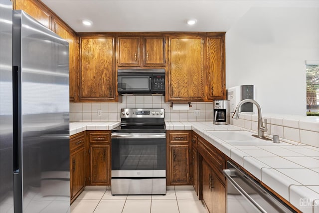 5600 Kirkside Dr Unit F, Bakersfield, CA 93311 - kitchen featuring stainless steel appliances, a sink, tile counters, tasteful backsplash, and recessed lighting