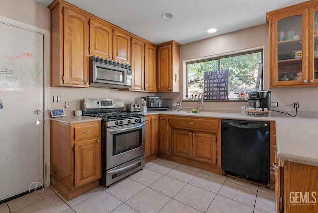 22381 William Tell Trl, Tehachapi, CA 93561 - kitchen with black appliances, light countertops, brown cabinetry, light tile patterned flooring, and glass insert cabinets