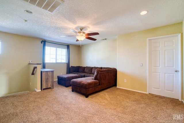 living area with ceiling fan, visible vents, and light colored carpet