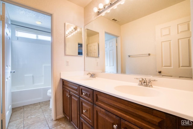 bathroom featuring a textured ceiling, tile patterned flooring, a sink, and toilet