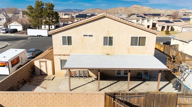 back of house featuring a residential view, a patio area, a mountain view, and stucco siding