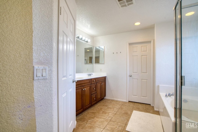 bathroom with a garden tub, a sink, visible vents, double vanity, and a stall shower