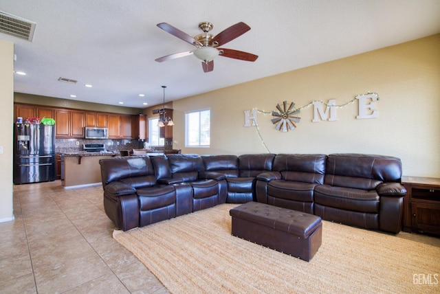 living room with light tile patterned floors, ceiling fan, visible vents, and recessed lighting