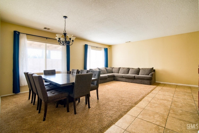 dining space featuring light tile patterned floors, baseboards, visible vents, an inviting chandelier, and a textured ceiling