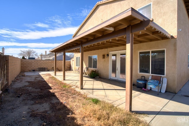 exterior space with a patio area, a fenced backyard, and stucco siding