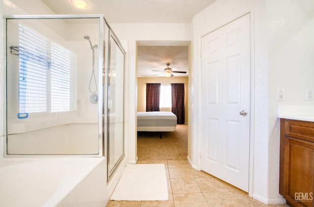 ensuite bathroom with a healthy amount of sunlight, a stall shower, tile patterned flooring, and ensuite bathroom