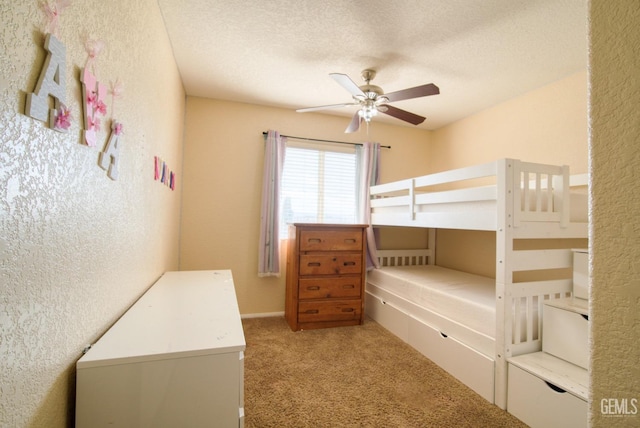 bedroom with carpet, a textured wall, and a textured ceiling