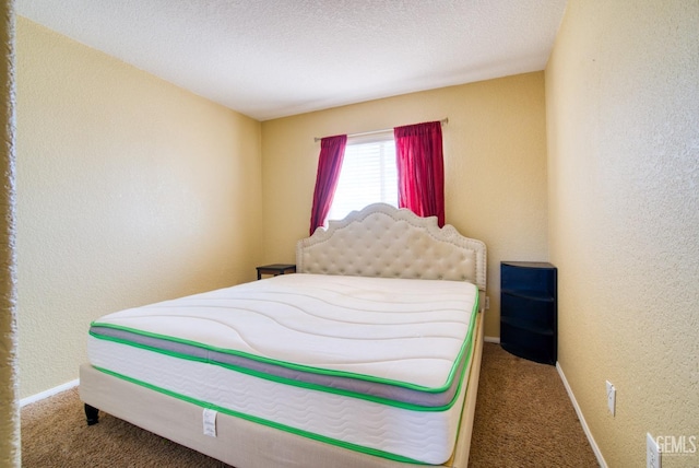 bedroom featuring a textured ceiling, baseboards, carpet flooring, and a textured wall