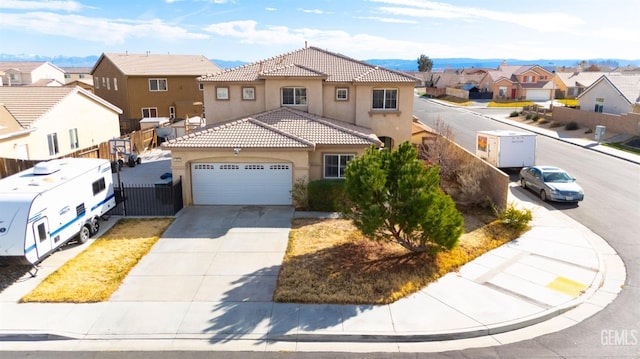 mediterranean / spanish home with stucco siding, an attached garage, a residential view, driveway, and a tiled roof