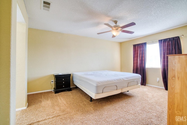 bedroom featuring carpet floors, baseboards, visible vents, and a textured ceiling