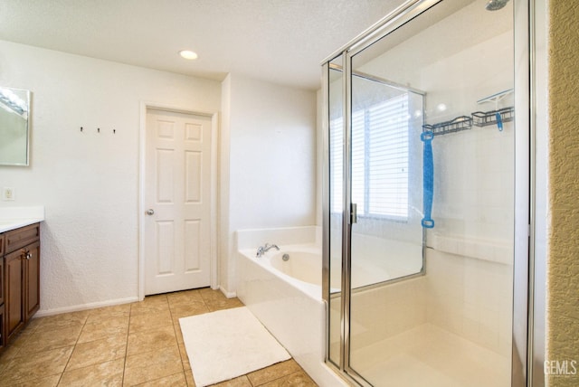 full bath with a stall shower, a garden tub, vanity, and tile patterned floors