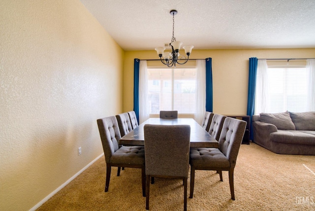 carpeted dining area featuring baseboards, a chandelier, a textured ceiling, and a textured wall