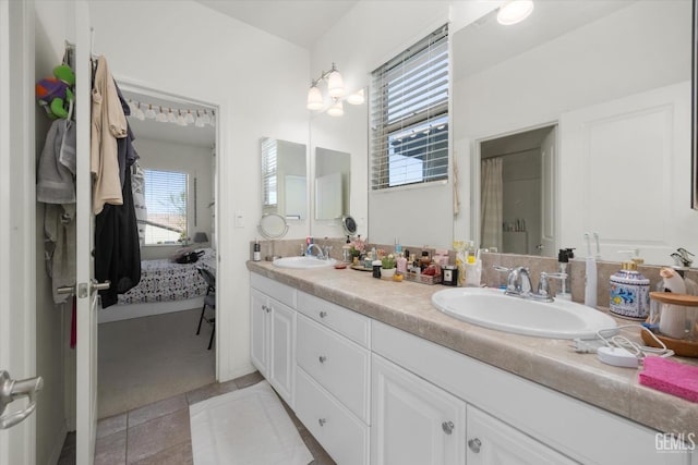 bathroom with a sink, double vanity, and tile patterned flooring