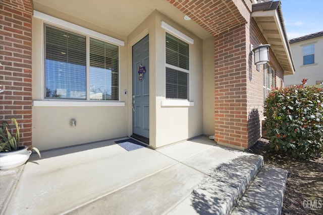 view of exterior entry featuring brick siding