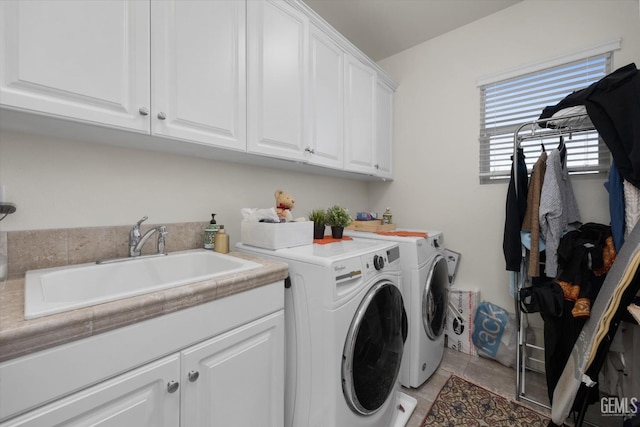 washroom with a sink, cabinet space, and washing machine and dryer