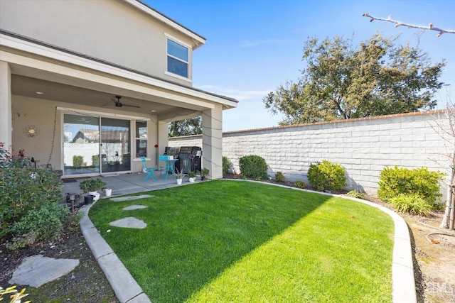 view of yard with a fenced backyard, a ceiling fan, and a patio