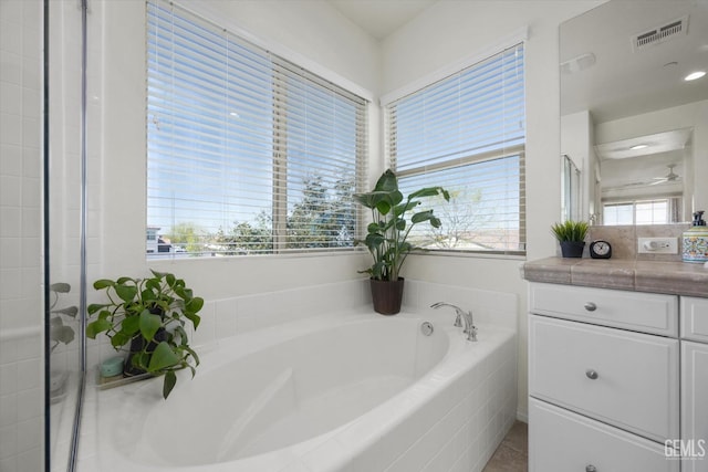 full bathroom with visible vents, a garden tub, and vanity